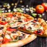 chiuda-su-delle-fette-della-pizza-di-merguez-con-il-peperone-dolce-e-il-formaggio-verde-oliva-del-salame_141793-2044